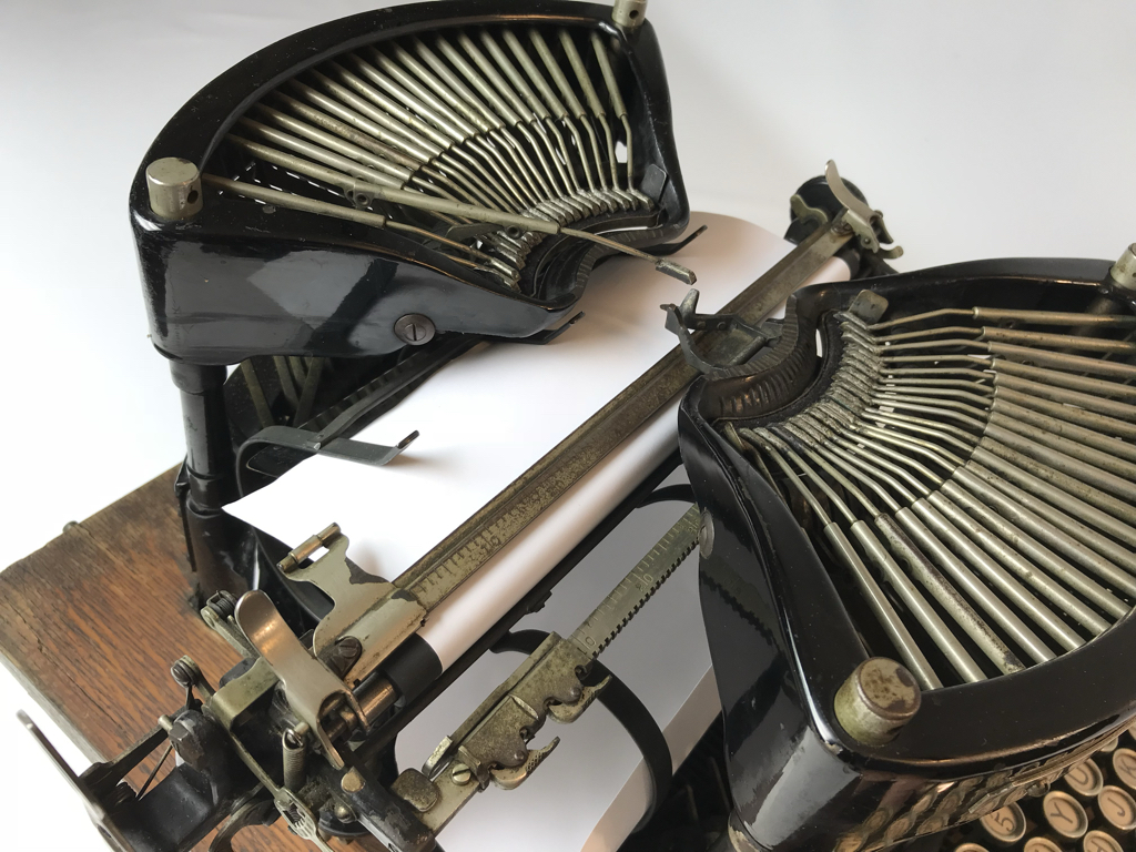 Type bars come from both the front and back of the machine to impact the paper. The front and back action looks something like grasshoppers jumping.